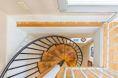 a spiral staircase in a house with an umbrella at High Cotton Beach Cottage in Inlet Beach