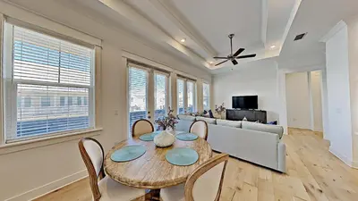 a dining room with a table and chairs and a couch at Settle By The Sea in Inlet Beach