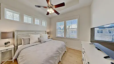 a bedroom with a bed and a ceiling fan at Settle By The Sea in Inlet Beach