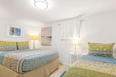 a bedroom with two beds and a window and two lamps at The Perfect View in Santa Rosa Beach