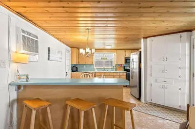 a kitchen with a counter and two stools in it at The Perfect View in Santa Rosa Beach