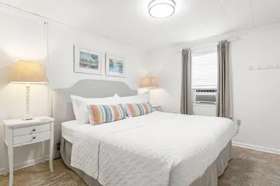 a white bedroom with a large bed and a lamp at The Perfect View in Santa Rosa Beach
