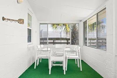 a white dining room with a table and white chairs at The Perfect View in Santa Rosa Beach