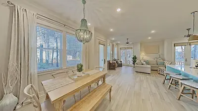 a living room with a table and a dining room at Prominence on 30A - Mint to Relax in Inlet Beach
