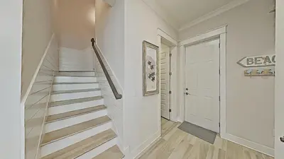 a hallway with stairs and a white door at Prominence on 30A - Mint to Relax in Inlet Beach
