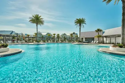 a large swimming pool with palm trees and buildings at Prominence on 30A - Mint to Relax in Inlet Beach