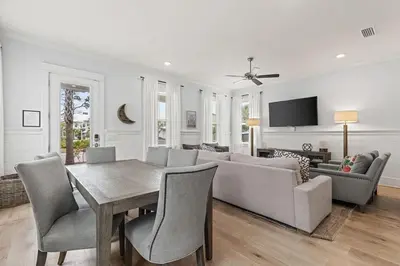 a living room with a table and a couch at Crabbing Hole Lane in Rosemary Beach