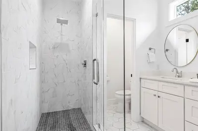 a white bathroom with a shower and a toilet at Shore To Please in Santa Rosa Beach