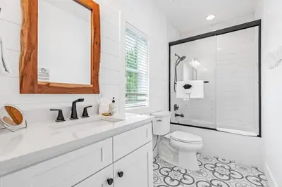 a white bathroom with a toilet and a mirror at Shore To Please in Santa Rosa Beach