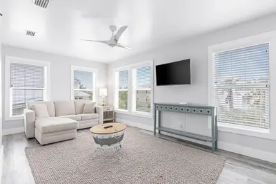 a living room with a couch and a tv at Shore To Please in Santa Rosa Beach