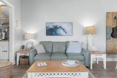 a living room with a green couch and a table at Time To Coast in Santa Rosa Beach