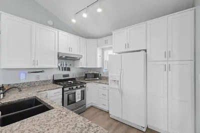a white kitchen with white cabinets and a sink at Time To Coast in Santa Rosa Beach
