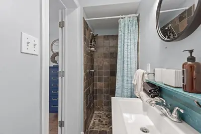 a bathroom with a shower and a sink and a mirror at Time To Coast in Santa Rosa Beach
