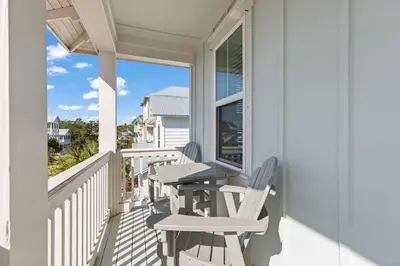 a porch with chairs and a table and a window at Casa Del Sol - Inlet Beach in Inlet Beach