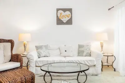 a living room with a white couch and a coffee table at The Little Pearl on 30A's Eastern Lake in Santa Rosa Beach