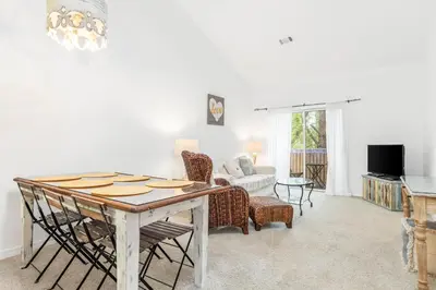 a living room with a table and a couch at The Little Pearl on 30A's Eastern Lake in Santa Rosa Beach
