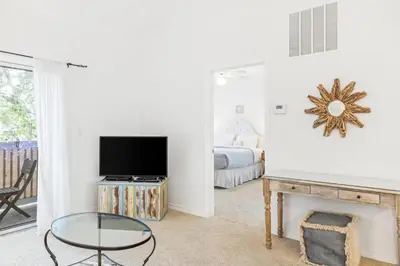 a living room with a tv and a fireplace at The Little Pearl on 30A's Eastern Lake in Santa Rosa Beach