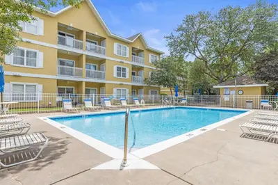 a swimming pool with chairs and a building at The Little Pearl on 30A's Eastern Lake in Santa Rosa Beach