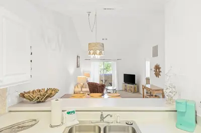 a kitchen with a sink and a living room at The Little Pearl on 30A's Eastern Lake in Santa Rosa Beach