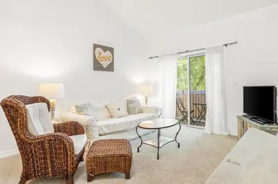 a living room with a couch and chairs and a tv at The Little Pearl on 30A's Eastern Lake in Santa Rosa Beach
