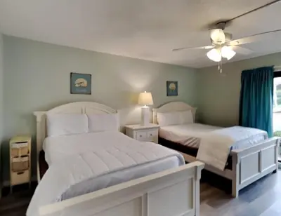 a bedroom with two beds and a ceiling fan at Edgewater Villa 1908 in Panama City Beach