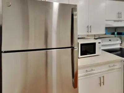 a stainless steel refrigerator in a kitchen with a microwave at Edgewater Villa 1913 in Panama City Beach