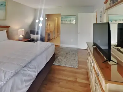 a bedroom with a bed and a flat screen tv at Edgewater Villa 1913 in Panama City Beach