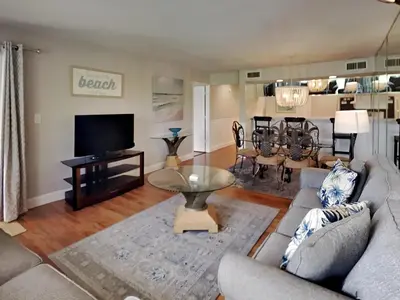 a living room with a couch and a tv at Edgewater Villa 1913 in Panama City Beach