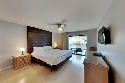 a bedroom with a bed and a flat screen tv at Edgewater Villa #2104 in Panama City Beach