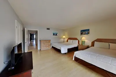 a bedroom with two beds and a flat screen tv at Edgewater Villa #2104 in Panama City Beach