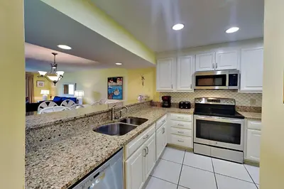 a kitchen with white cabinets and a sink at Edgewater Villa 1916 in Panama City Beach