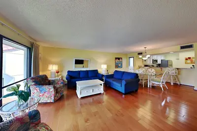 a living room with blue couches and a table at Edgewater Villa 1916 in Panama City Beach