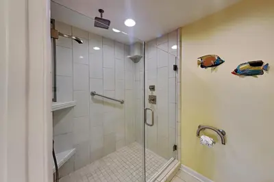 a shower with a glass door in a bathroom at Edgewater Villa 1916 in Panama City Beach