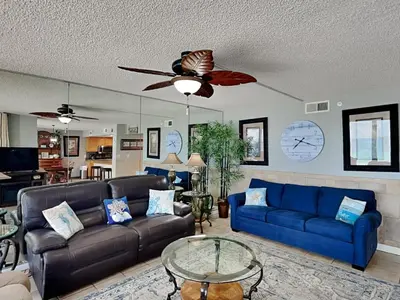 a living room with blue couches and a ceiling fan at Edgewater Tower III 513 in Panama City Beach
