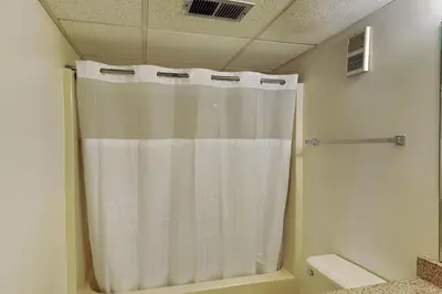 a bathroom with a shower with a white shower curtain at Edgewater Tower III #713 in Panama City Beach
