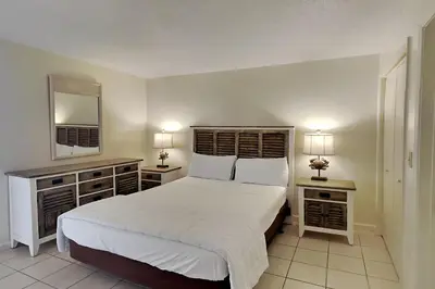a bedroom with a large white bed and two night stands at Edgewater Tower III #713 in Panama City Beach