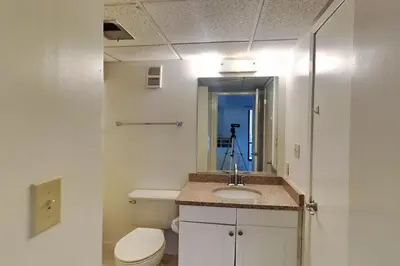 a bathroom with a toilet and a sink and a mirror at Edgewater Tower III #713 in Panama City Beach