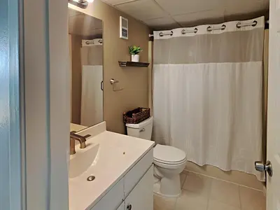 a white bathroom with a toilet and a sink at Edgewater Tower III 911 in Panama City Beach