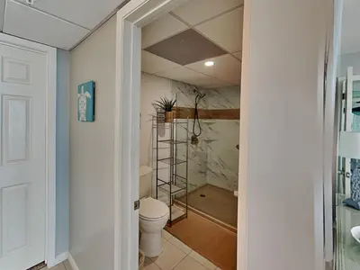 a bathroom with a toilet and a walk in shower at Edgewater Tower III 911 in Panama City Beach