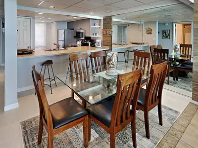 a dining room and kitchen with a glass table and chairs at Edgewater Tower III 911 in Panama City Beach