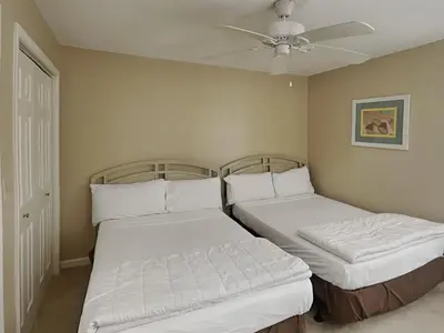 two beds in a room with a ceiling fan at Edgewater Tower III #1002 in Panama City Beach