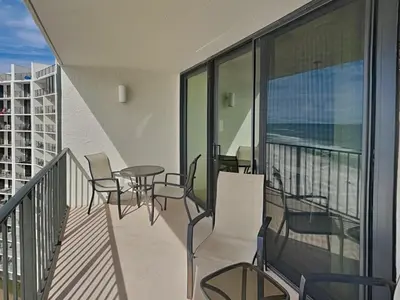 a balcony with chairs and tables on a building at Edgewater Tower III #1002 in Panama City Beach