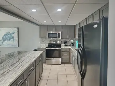 a kitchen with a stainless steel refrigerator and appliances at Edgewater Tower III #1002 in Panama City Beach