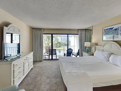 a bedroom with a large bed and a balcony at Edgewater Villa 117 in Panama City Beach