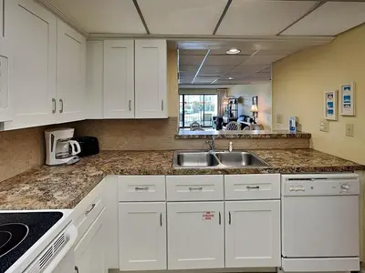 a kitchen with white cabinets and a sink at Edgewater Villa 117 in Panama City Beach