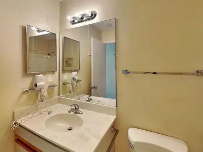 a bathroom with a sink and a toilet and a mirror at Edgewater Villa 117 in Panama City Beach