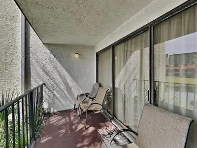 two chairs on the balcony of a building at Edgewater Villa 117 in Panama City Beach