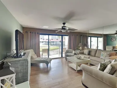 a living room with a couch and a tv at Edgewater Villa 124 in Panama City Beach