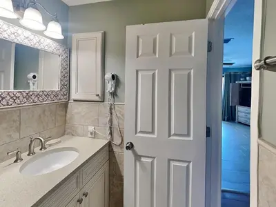 a bathroom with a sink and a white door at Edgewater Villa 124 in Panama City Beach