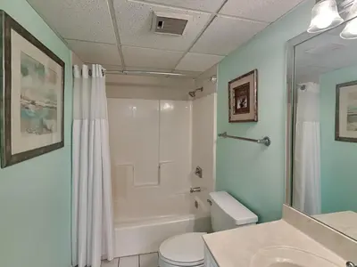 a bathroom with a shower and a toilet and a sink at Edgewater Villa 124 in Panama City Beach